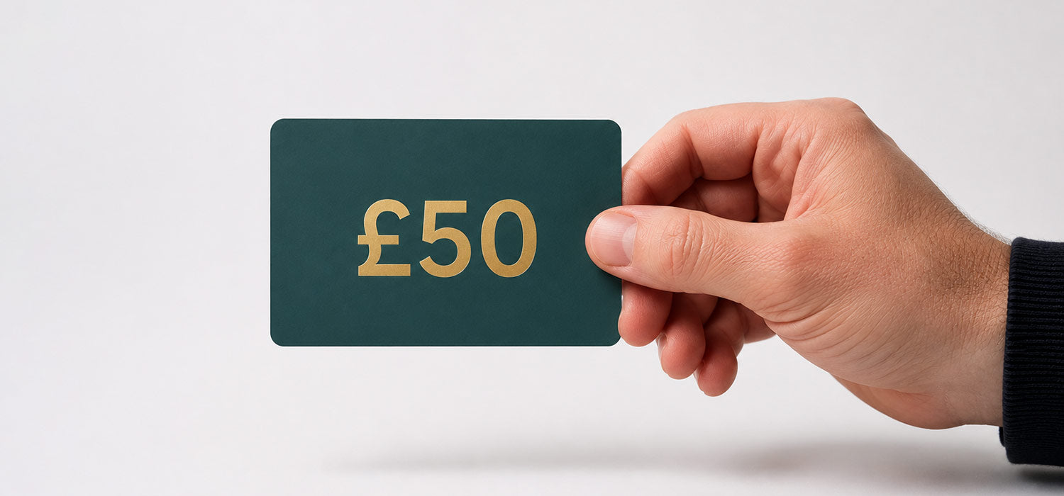 Hand holding a £50 gift card against a white background