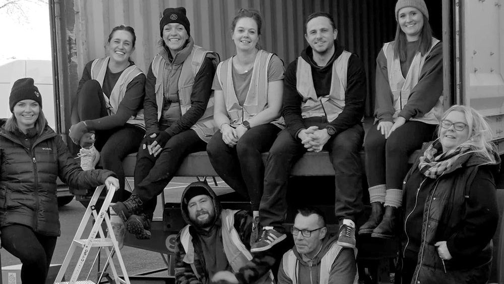 Group of people posing in front of a truck