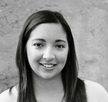 Black and white photo of a person with long hair against a plain background